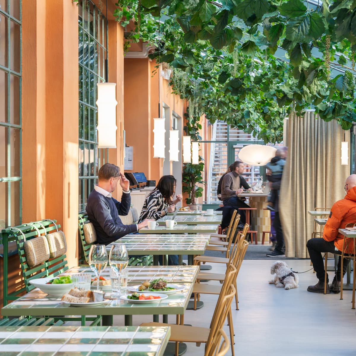 En grupp människor som sitter vid bord på en restaurang.